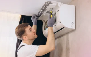 A technician performing maintenance on an outdoor air conditioning unit to ensure efficient operation.