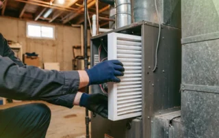 Technician performing heating furnace maintenance in Warwick home
